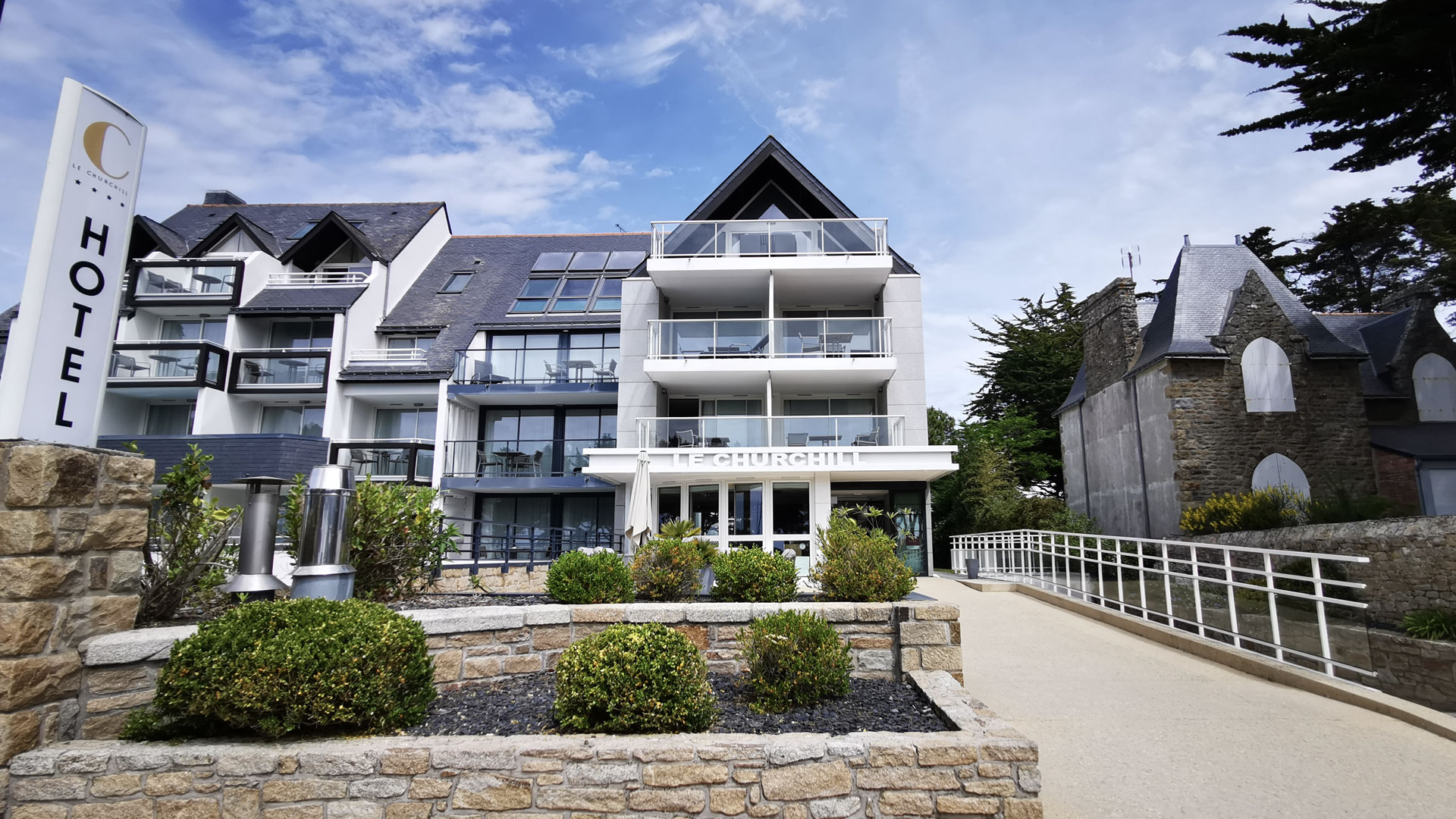 Extérieur de l’Hôtel Le Churchill à Carnac, avec un cadre élégant et un accès direct à la plage en Morbihan.