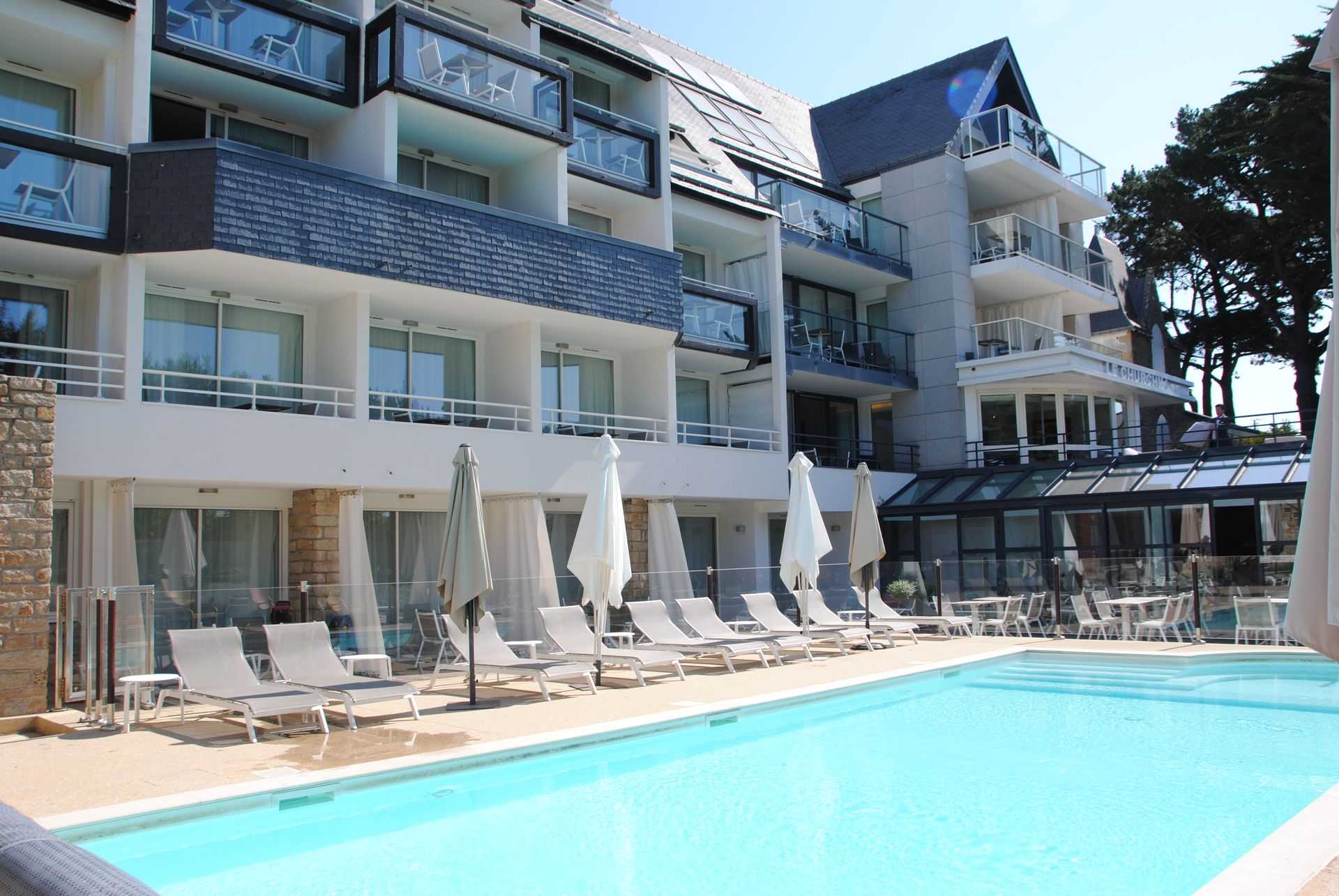 Piscine extérieure chauffée à l’Hôtel Le Churchill à Carnac, avec vue sur mer pour une détente absolue en Morbihan.