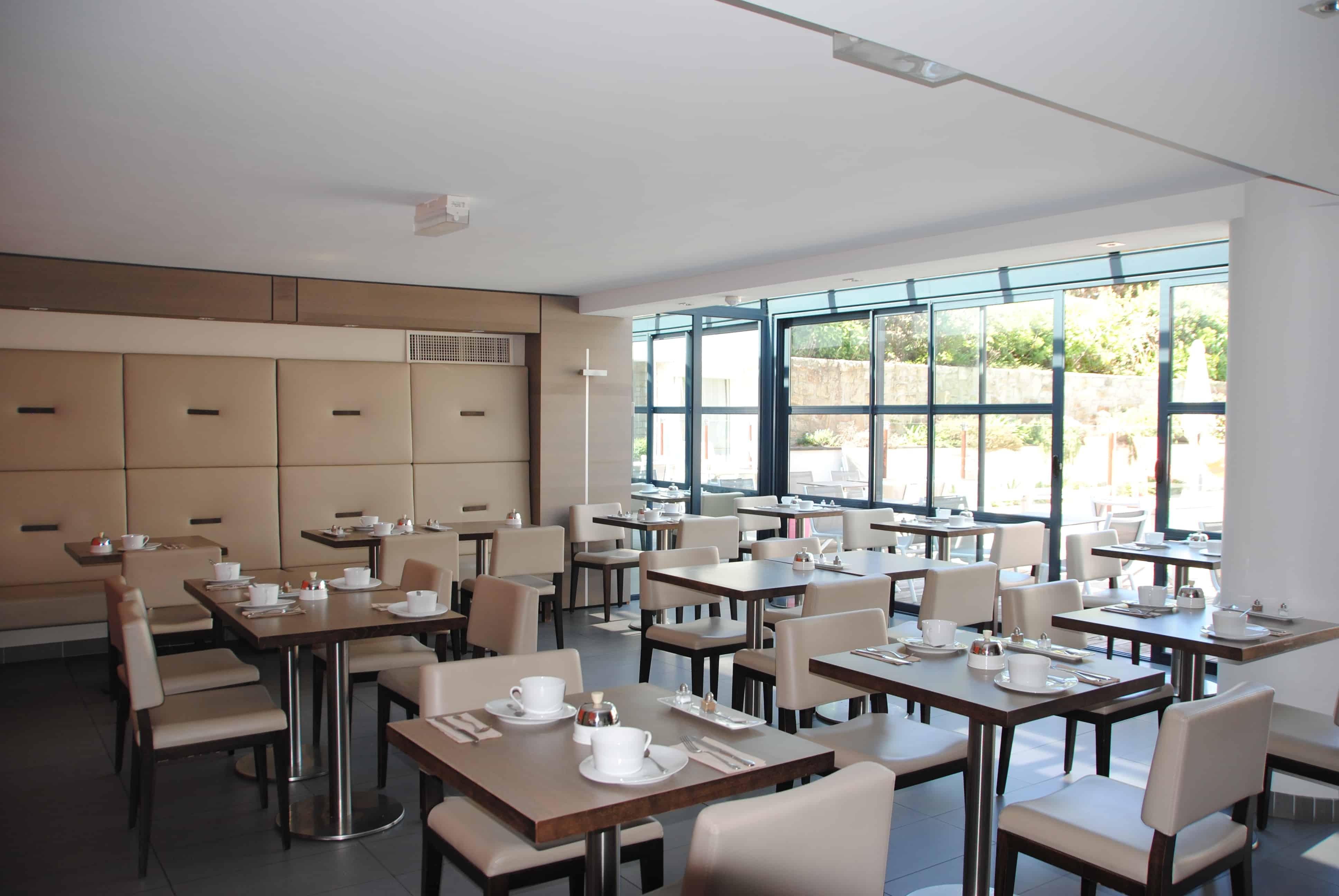 Salle de restaurant à l’Hôtel Le Churchill à Carnac, avec une ambiance élégante et vue sur mer en Morbihan.