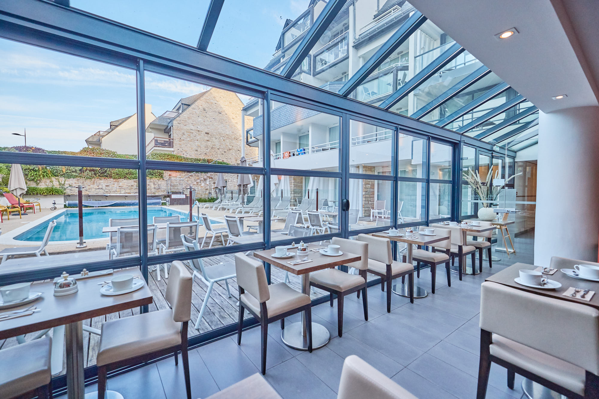 Baie vitrée donnant sur la piscine chauffée à l’Hôtel Le Churchill à Carnac, avec vue sur mer en Morbihan.